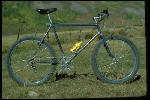 Ritchey bike labeled, T. Ritchey,  built for Gary Fisher. One of the first three ballooners built by Tom Ritchey in Redwood City, CA in March 1979. MountainBikes was founded in September 1979. Photo taken in Crested Butte, CO, September 1979. Owned by Gary Fisher of San Anselmo, CA. Blue frame. Static side view, in field. 